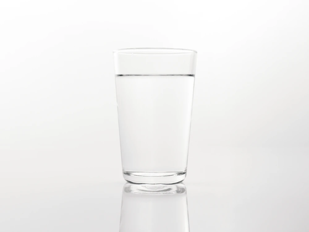 A plain glass of water on a light background.