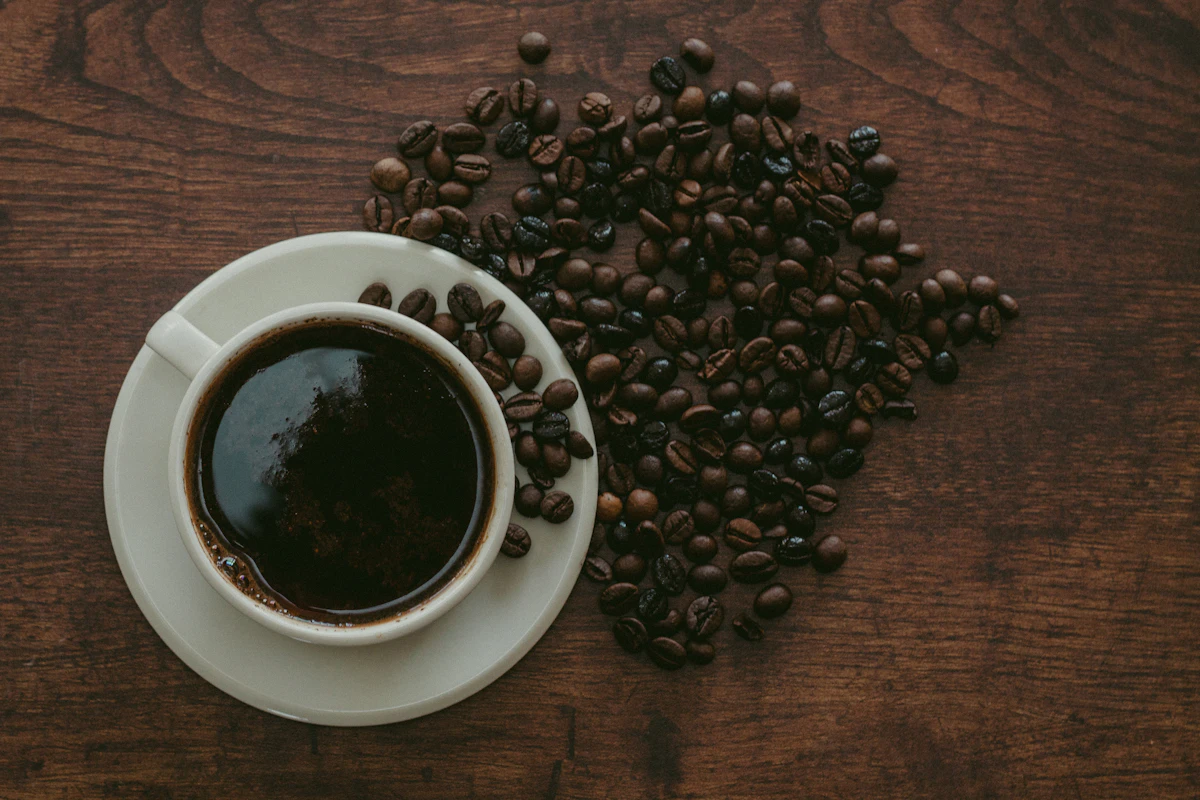 A cup of coffee with coffee beans.