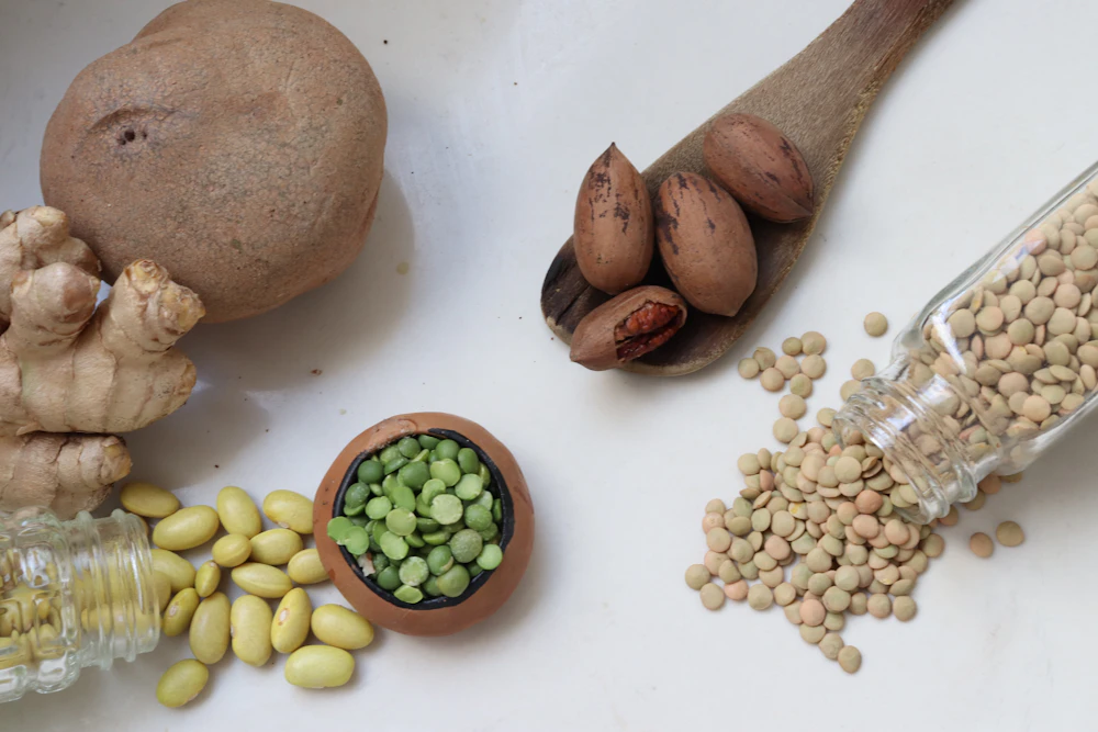 Lentils, split peas, beans and nuts arranged on a light surface.